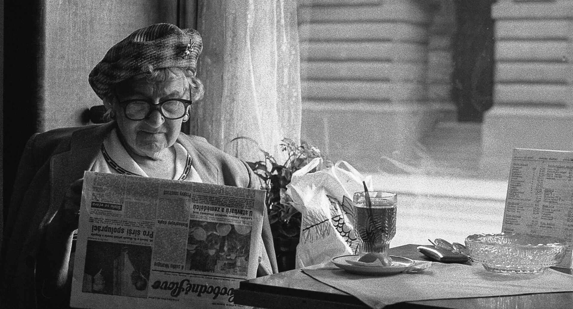 Person reading a newspaper in a café