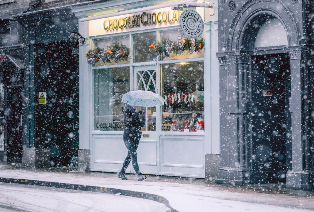 Person walking in the snow on the high street