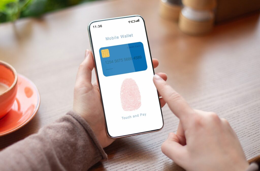 Person Holding Phone Showing Mobile Wallet App With Fingerprint Icon