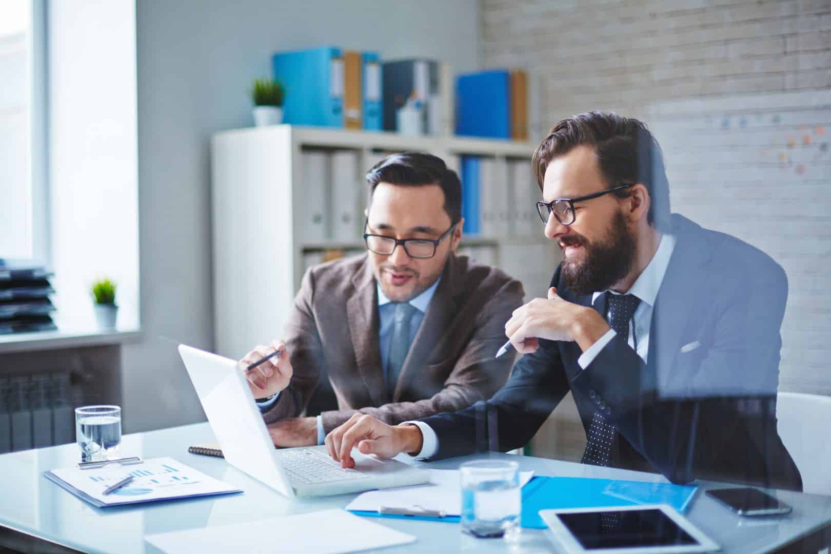 two men with laptop working together