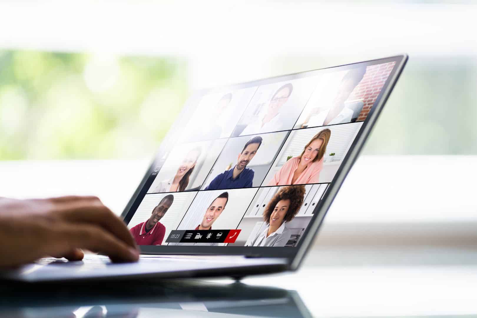 User on a laptop watching a webinar with participants on screen