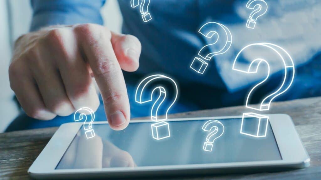 man using tablet with question marks