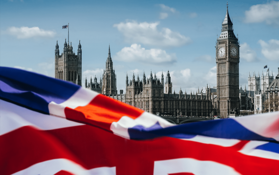 united Kingdom flag with houses of parliament in the background